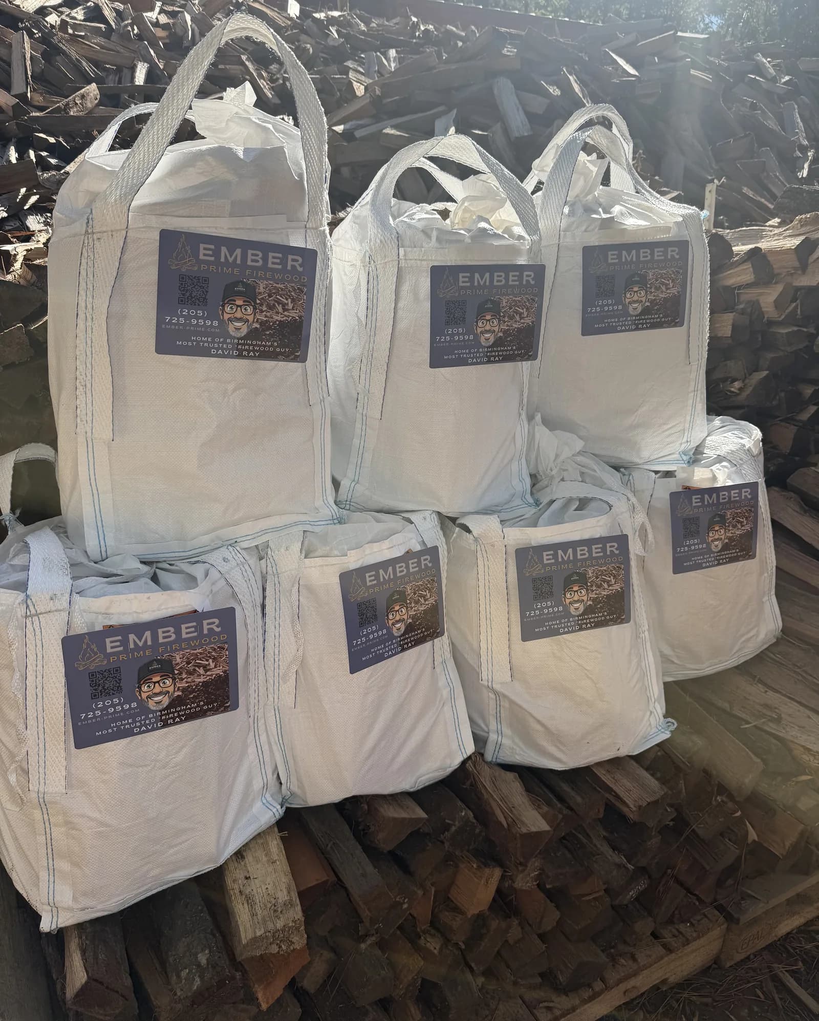 Ember Prime firewood bags, each with the Ember Prime card, stacked at the yard